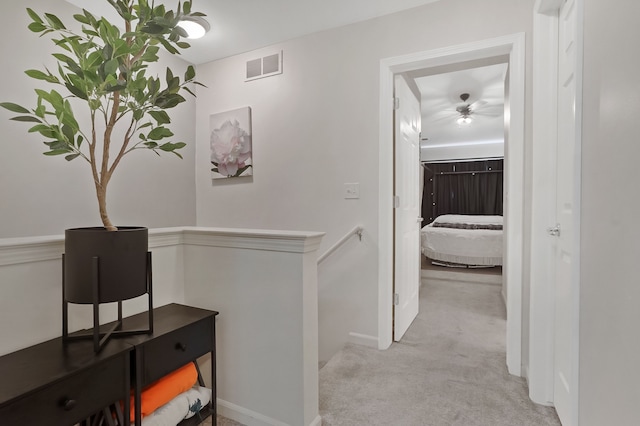 corridor with carpet floors, an upstairs landing, and baseboards