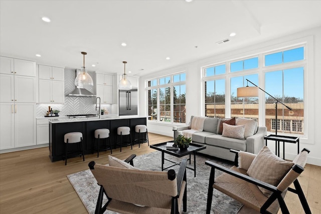 living room featuring visible vents, recessed lighting, and light wood-style floors