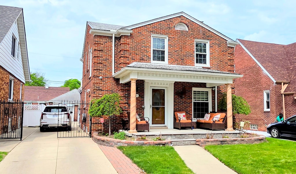 traditional-style home with fence, a gate, an outdoor living space, and brick siding