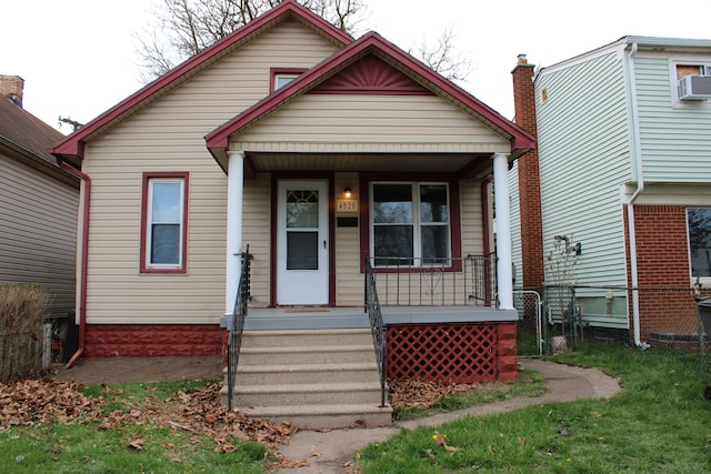 view of front of home with a porch, fence, and cooling unit