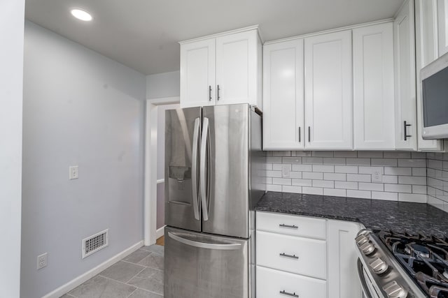 kitchen featuring visible vents, white cabinetry, decorative backsplash, baseboards, and appliances with stainless steel finishes