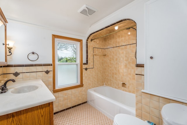full bathroom featuring tile walls, toilet, and visible vents