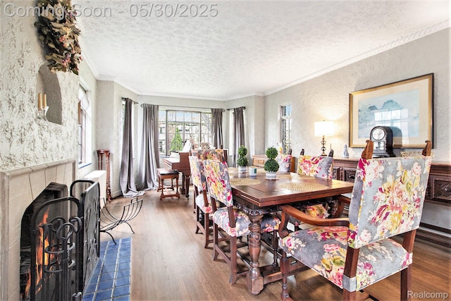 1301 Bishop Rd, Grosse Pointe Park, MI 48230 - dining room featuring wood finished floors, ornamental molding, a textured wall, a textured ceiling, and a tiled fireplace