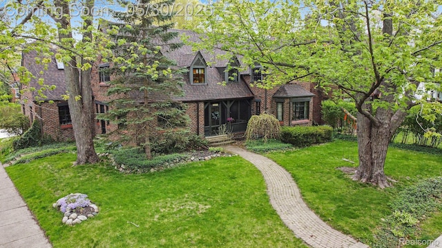 1301 Bishop Rd, Grosse Pointe Park, MI 48230 - tudor-style house featuring a front lawn and brick siding