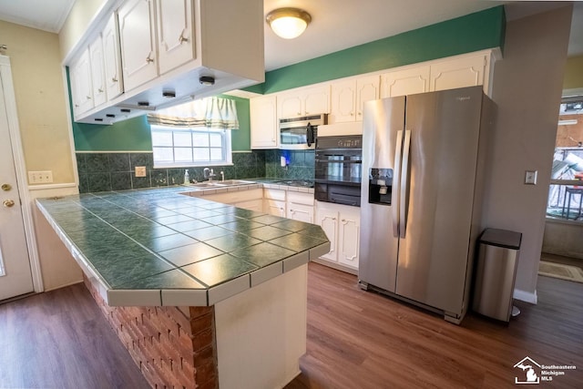 3336 Springdale St, Lambertville, MI 48144 - kitchen with a sink, dark wood-style flooring, a peninsula, and black appliances