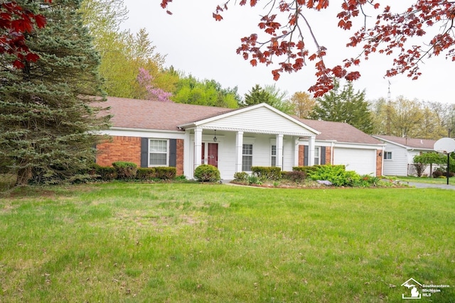 3336 Springdale St, Lambertville, MI 48144 - greek revival house featuring an attached garage, concrete driveway, brick siding, and a front yard