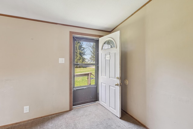 doorway to outside with baseboards, ornamental molding, and light colored carpet