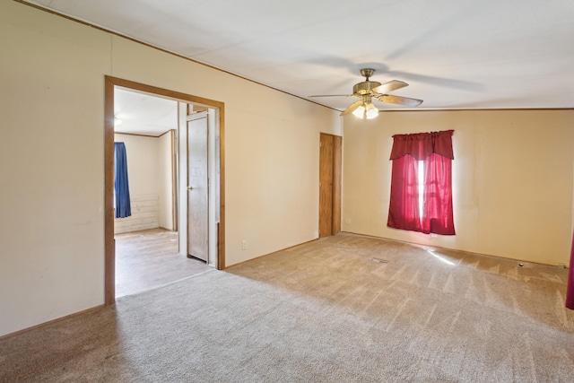carpeted empty room featuring a ceiling fan