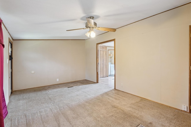 unfurnished room featuring carpet floors, a ceiling fan, and washer / clothes dryer