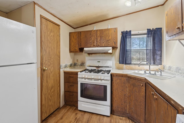 kitchen featuring a sink, white appliances, light wood-type flooring, under cabinet range hood, and ornamental molding
