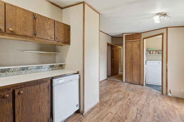 kitchen with brown cabinetry, washer / clothes dryer, dishwasher, light countertops, and light wood finished floors