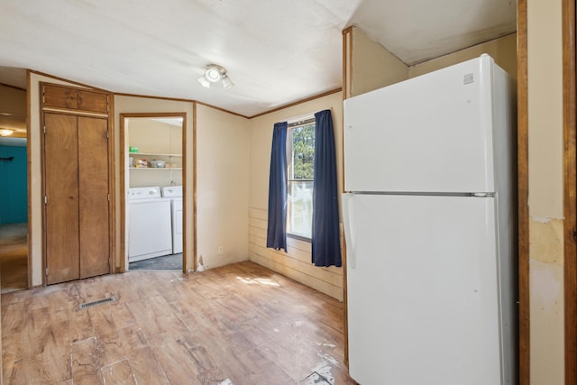 kitchen featuring separate washer and dryer, freestanding refrigerator, visible vents, and light wood-type flooring