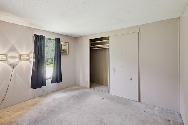 unfurnished bedroom featuring a closet, carpet flooring, and a textured ceiling