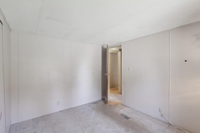 unfurnished bedroom with light carpet and visible vents