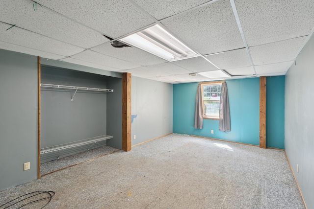 unfurnished bedroom with a paneled ceiling, carpet, and a closet