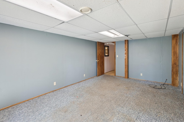finished basement featuring carpet flooring, baseboards, and a drop ceiling