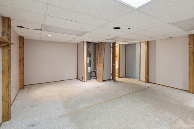 finished basement with carpet floors, a paneled ceiling, and electric water heater