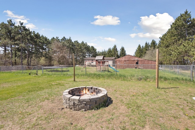view of yard with a playground, a fire pit, and a fenced backyard