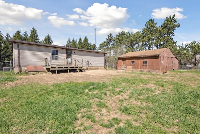 back of property featuring a lawn, fence, and a deck