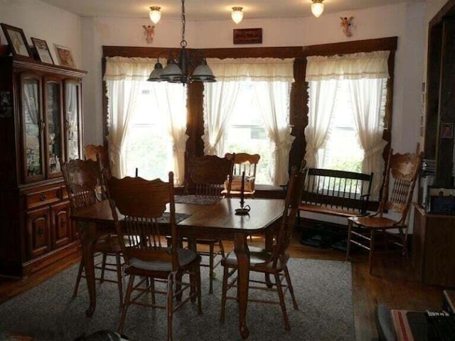 dining space featuring wood finished floors, a chandelier, and a wealth of natural light