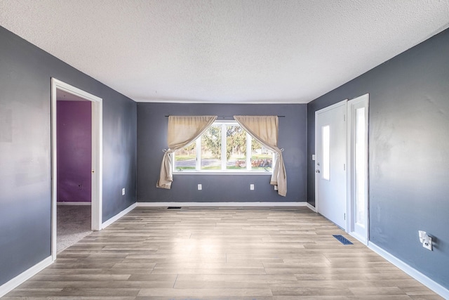 6093 Porter Rd, Grand Blanc, MI 48439 - empty room featuring visible vents, a textured ceiling, and wood finished floors