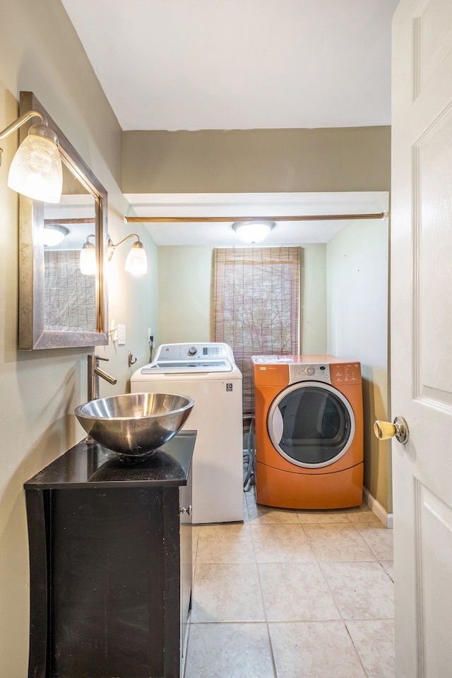 6093 Porter Rd, Grand Blanc, MI 48439 - laundry area featuring washing machine and clothes dryer, light tile patterned flooring, and a sink