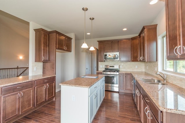 kitchen featuring dark wood-style flooring, light stone counters, a sink, stainless steel appliances, and backsplash