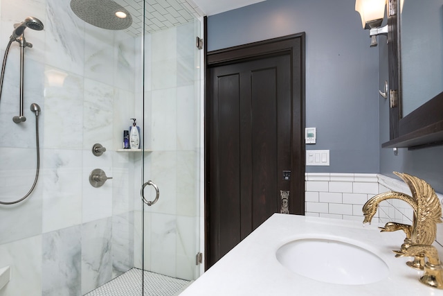 bathroom featuring a wainscoted wall, tile walls, a sink, and a stall shower