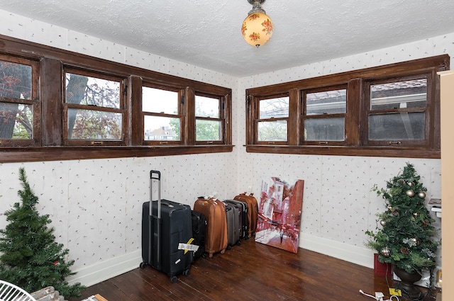 miscellaneous room featuring baseboards, dark wood finished floors, and wallpapered walls
