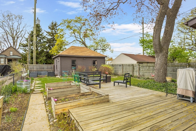 wooden terrace with a fenced backyard, an outdoor structure, and a garden