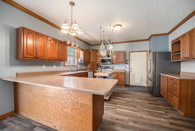 kitchen featuring a peninsula, dark wood-type flooring, brown cabinets, appliances with stainless steel finishes, and a notable chandelier