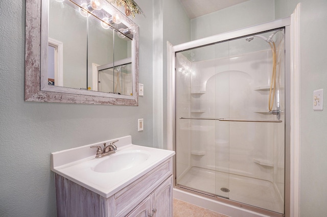 bathroom with a shower stall and vanity