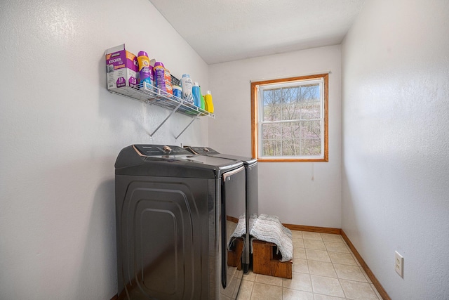 laundry room featuring light tile patterned floors, baseboards, laundry area, and washer and dryer