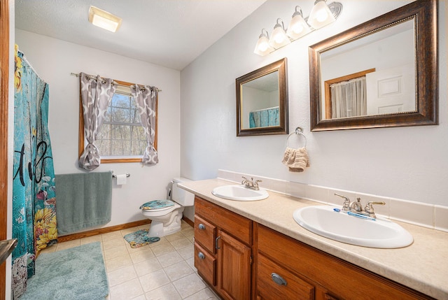 bathroom featuring a sink, tile patterned flooring, toilet, and double vanity