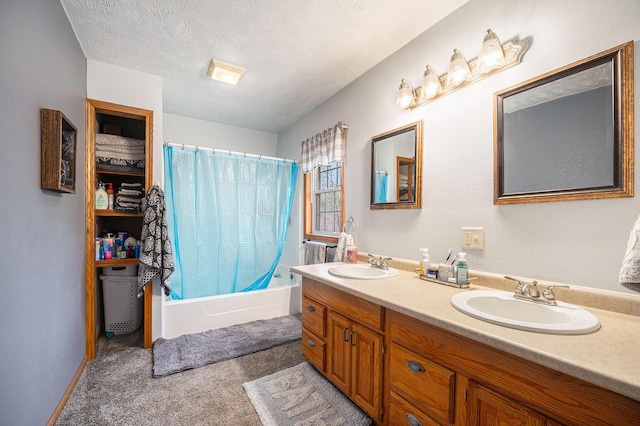 full bathroom featuring double vanity, shower / bath combo with shower curtain, a textured ceiling, and a sink