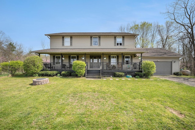 view of front of property featuring covered porch, an attached garage, a fire pit, and aphalt driveway