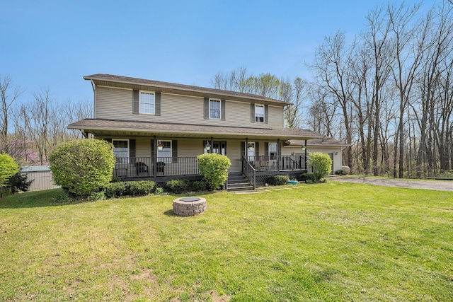 farmhouse inspired home with a porch, a fire pit, driveway, and a front yard