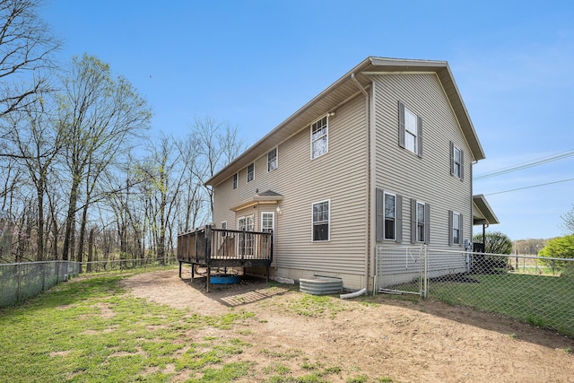 rear view of property with a fenced backyard, a yard, and a deck