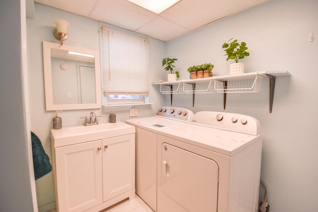 washroom featuring cabinet space, a sink, and washer and clothes dryer