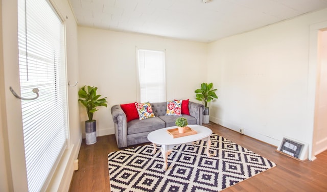 living room featuring visible vents, baseboards, and wood finished floors