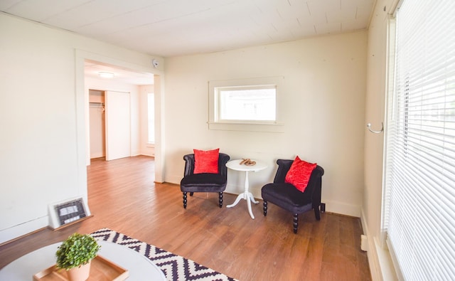 living area with baseboards, wood finished floors, and visible vents