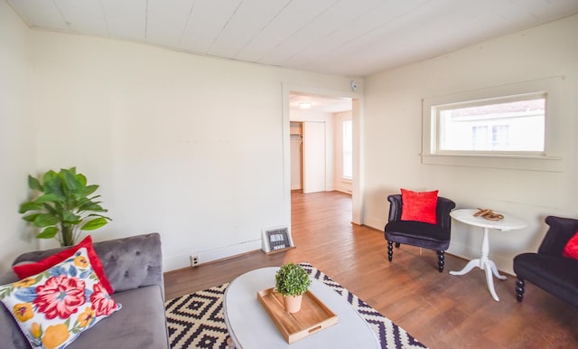 living area featuring baseboards, visible vents, and wood finished floors