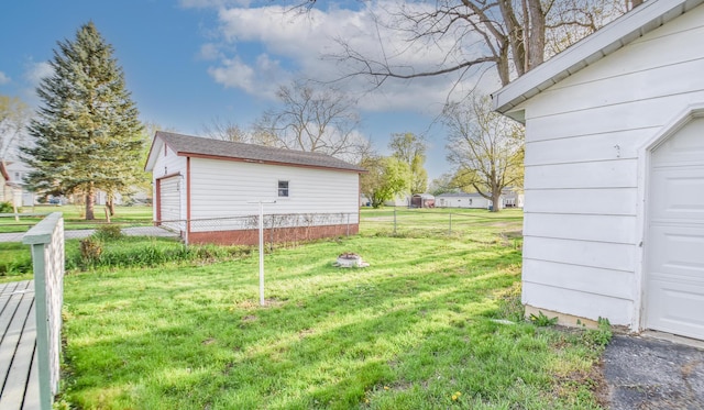 view of yard featuring fence, an outbuilding, and a garage