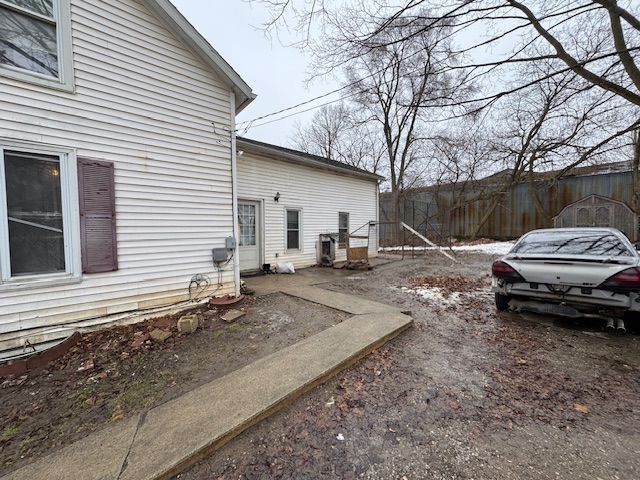 view of side of property with fence and central AC unit