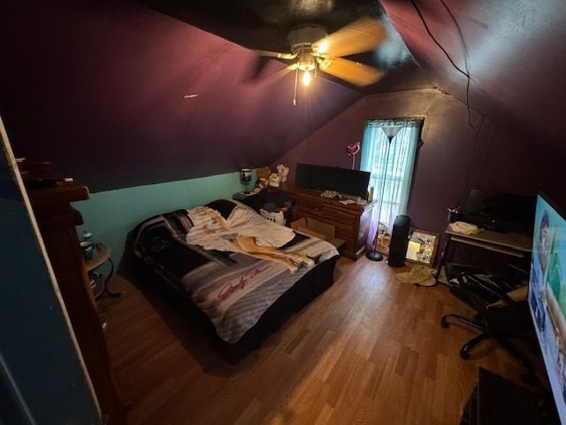 bedroom featuring ceiling fan, wood finished floors, and lofted ceiling