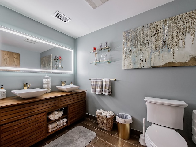 17477 Iris Cir, Clinton Township, MI 48036 - full bath featuring toilet, baseboards, double vanity, and wood finish floors