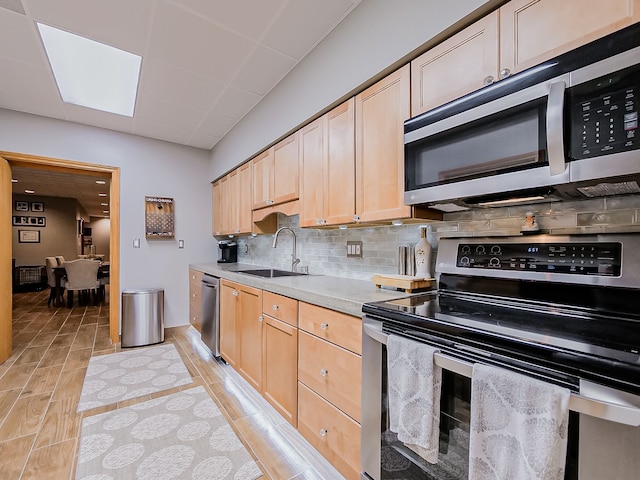 17477 Iris Cir, Clinton Township, MI 48036 - kitchen featuring appliances with stainless steel finishes, light brown cabinets, tasteful backsplash, a sink, and light countertops
