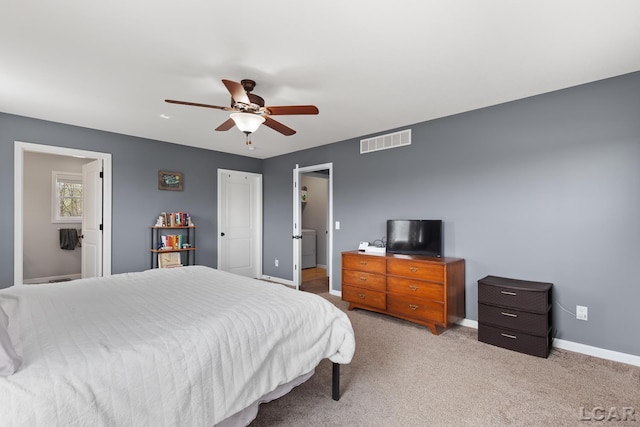 bedroom with light colored carpet, washer / clothes dryer, a ceiling fan, baseboards, and visible vents