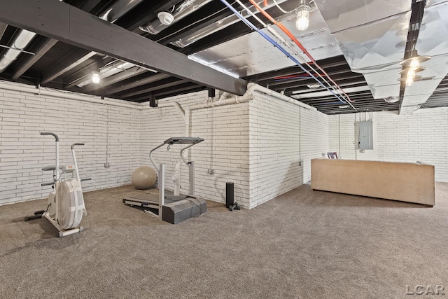 unfinished below grade area featuring carpet flooring, electric panel, and brick wall