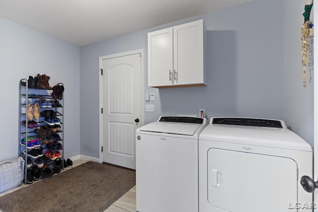 laundry room featuring washing machine and clothes dryer, baseboards, and cabinet space